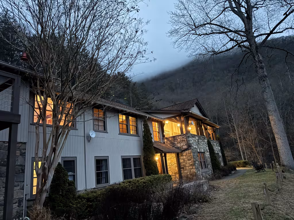 The lodge at dusk, lights on and low cloud on the ridge