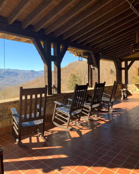 Rocking chairs on the covered Grand Patio, looking out over the tiled floor to the mountains