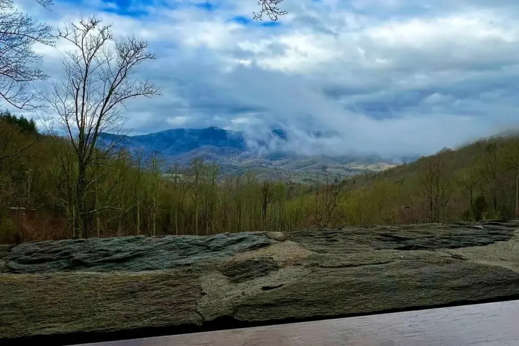 Morning clouds in the valley below the lodge's stone wall