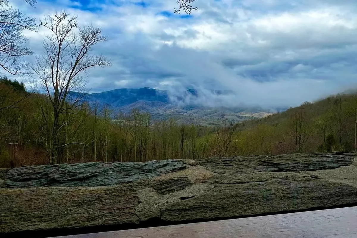 Morning clouds in the valley below the lodge's stone wall