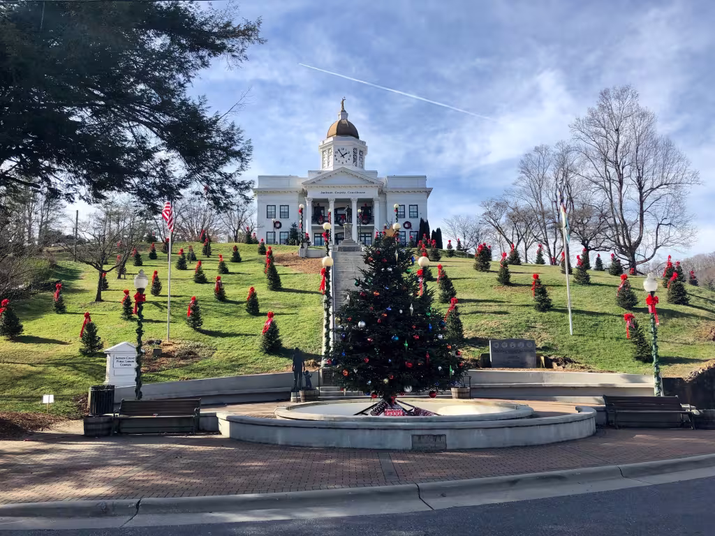 The Sylva courthouse lit for Christmas, with a decorated tree at the foot of the steps